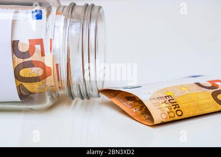 Komposition mit Spargeld-Banknoten (50 EURO) in einem Glasgefäß. Konzept der Investition und halten Geld, Nahaufnahme isoliert. Stockfoto