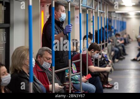 Moskau, Russland. Mai 2020. Passagiere, die Gesichtsmasken und Handschuhe tragen, werden am 12. Mai 2020 in einem U-Bahn-Zug in Moskau, Russland, gesehen. Russland hat am Dienstag 232,243 bestätigte COVID-19-Fälle gemeldet. Kredit: Alexander Zemlianichenko Jr/Xinhua/Alamy Live News Stockfoto