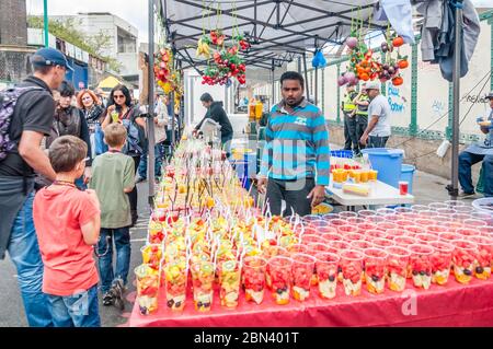 Farbenfroher Street Food-Stand, der Fruchtsaft auf einem Sonntagsmarkt in der Brick Lane in London verkauft Stockfoto