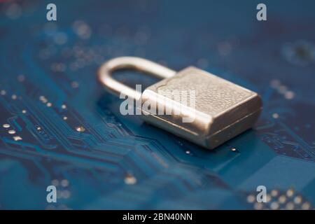 Geschlossene Sicherheitsverriegelung auf blauer Computerplatine im Hintergrund. Cyber Security, Virenschutzkonzept. Stockfoto