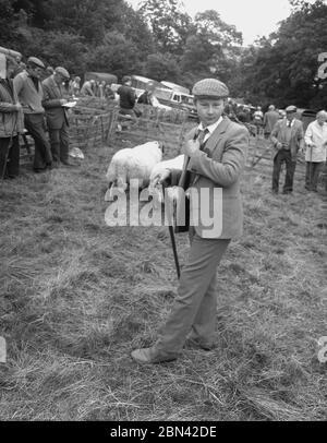 1980s, ein gut gekleideter junger Richter, in einer Sportjacke und Krawatte und Stoffkappe, in einem Schafstall bei der Farndale Show, Yorkshire, England, Großbritannien. Stockfoto