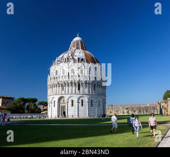 Das Baptisterium San Giovanni (Battistero di San Giovanni) von Pisa wird von der Sonne in der Piazza dei Miracoli, Pisa, Italien, beleuchtet Stockfoto