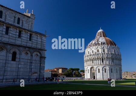 Das Baptisterium San Giovanni (Battistero di San Giovanni) von Pisa wird von der Sonne in der Piazza dei Miracoli, Pisa, Italien, beleuchtet Stockfoto