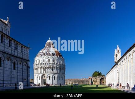 Das Baptisterium San Giovanni (Battistero di San Giovanni) von Pisa wird von der Sonne in der Piazza dei Miracoli, Pisa, Italien, beleuchtet Stockfoto