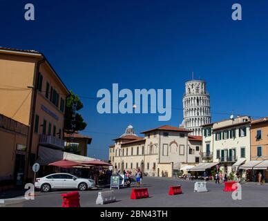 Der Schiefe Turm von Pisa erhebt sich an einem hellen, sonnendurchfluteten Tag mit klarem blauen Himmel über dem Stadtzentrum von Pisa, Italien Stockfoto