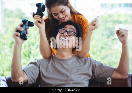 Glücklich Senior Asain Paar, die Spiel con halten Stockfoto