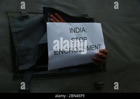 Kathmandu, Nepal. Mai 2020. Ein Aktivist der Human Rights and Peace Society Nepal hält ein Schild auf der Rückseite eines Polizeifahrzeugs während eines Protestes gegen die indische Regierung vor der indischen Botschaft in Kathmandu, Nepal, 12. Mai 2020 Quelle: Dipen Shrestha/ZUMA Wire/Alamy Live News Stockfoto