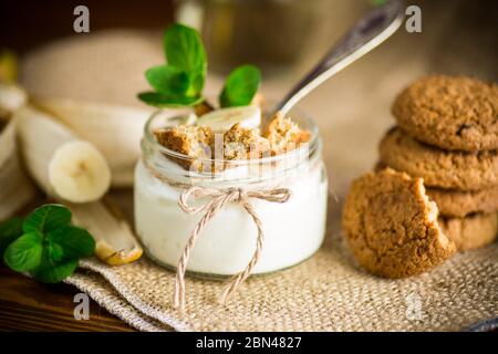 Süßer hausgemachter Joghurt mit frischen Bananen und Scheiben Haferflocken Stockfoto