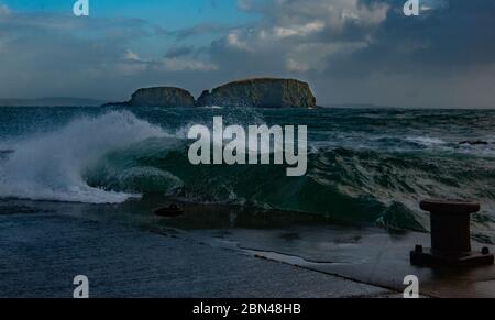 Wellen stürzen sich auf den Ballintoy Harbour, Causeway Coast, Nordirland Stockfoto