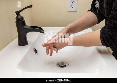 Weibliche Hände waschen zwischen den Fingern an den Händen zum Schutz vor Keimen Stockfoto