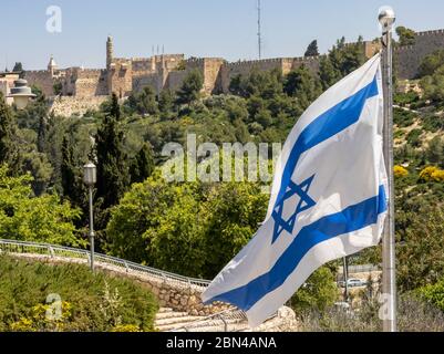 Jerusalem, Israel - 5. Mai 2020: Die alte Stadt der Mauern Jerusalems mit dem Turm Davids. Im Vordergrund steht die Nationalflagge Israels. Stockfoto