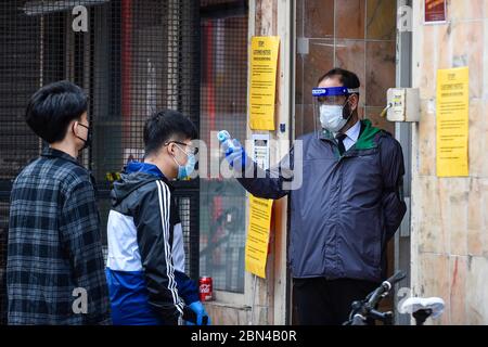 London, Großbritannien. 12 Mai 2020. Ein Wachmann kontrolliert die Temperatur der Kunden in einem Supermarkt in Chinatown während der laufenden Coronavirus Pandemie gesperrt. Normalerweise sind die Straßen mit Touristen und Besuchern überfüllt, aber als Folge von Covid 19, wird der Fußabfall deutlich reduziert. Kredit: Stephen Chung / Alamy Live News Stockfoto