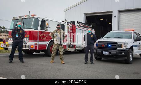 Feuerwehr und Sicherheitskräfte der Connecticut Air National Guard Feuerwehr und Mitarbeiter der Bradley Air National Guard Base Feuerwehr in East Granby, Connecticut, 20. April 2020. Die Basisfeuerwehr und das 103. Sicherheitskräfte-Geschwader arbeiten weiterhin rund um die Uhr, um die Sicherheit des Personals der Connecticut Air National Guard zu gewährleisten und um die gegenseitige Hilfe der Notfallhelferpartner während der COVID-19-Pandemie zu unterstützen. (USA Foto der Air National Guard von Staff Sgt. Steven Tucker) Stockfoto