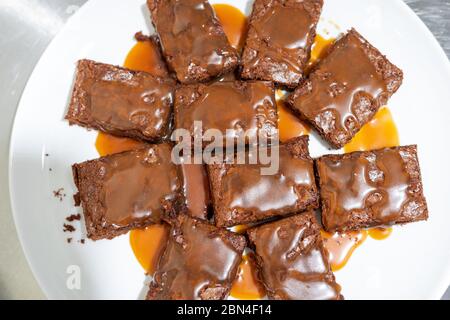 Draufsicht auf einem Teller mit Brownie Stücke mit gesalzener Karamellsauce gegossen Stockfoto