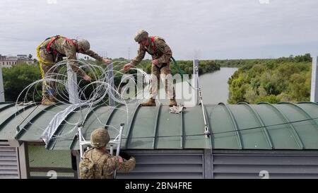 Soldaten concertina Draht in eine Position entlang der südwestlichen Grenze der Vereinigten Staaten in der Nähe von Hidalgo, Texas bereitstellen. Us-Armee Norden ist unter der Aufsicht des US Northern Command an der südwestlichen Grenze das Ministerium für Heimatschutz und der Zoll und Grenzschutz Mission der Grenze zu unterstützen. November 2, 2018. Stockfoto