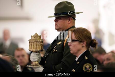 Ein US-Grenzpolizei-Agent trägt die Eucharistie während der 25. Jährlichen Blauen Messe in der St. Patrick’s Catholic Church in Washington, D.C. am 7. Mai 2019 zum Altar. Stockfoto