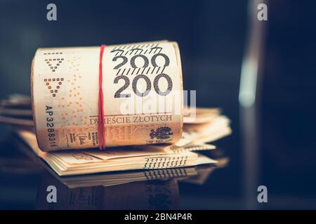 Nahaufnahme Von Großem Stapel Und Rolle Der Polnischen Zweihundert Zloty Papierwährung, Die Auf Dem Tisch Sitzt. Stockfoto