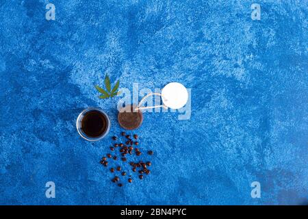 Cannabisseife, CBD-Öl und Kaffeebohnen auf dunkelblauem Hintergrund. Medizinisches Marihuana in Kosmetika. Stockfoto