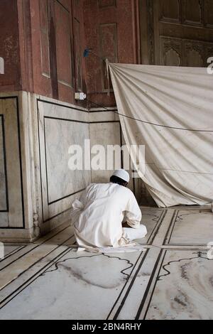 Delhi, Indien - Juli 29 2012 - Mann, der in der Jama Masjid Moschee betet, erbaut vom Mogul-Kaiser Shah Jahan, einer der größten Moscheen in Indien Stockfoto