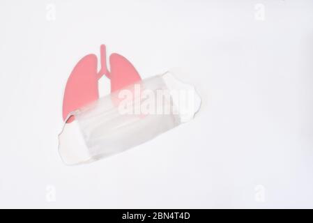 Coronavirus-Konzept. Papierlungen mit medizinischer Maske. Minimal Paper Art. Welttuberkulosetag oder Weltlungstag Konzept. Rosa Loch Lungen als Symbol für Stockfoto