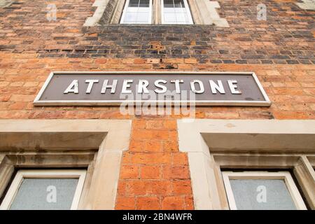 Die alten originalen Zugschilder an der Seite der Bahnsteigegebäude am Bahnhof London North Western, Atherstone, North Warwickshire. Der Bahnhof war einst ein Hauptbahnhof, jetzt gibt es Züge nach London, obwohl Hochgeschwindigkeitszüge direkt durch den Bahnhof fahren. Stockfoto