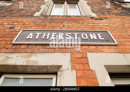 Die alten originalen Zugschilder an der Seite der Bahnsteigegebäude am Bahnhof London North Western, Atherstone, North Warwickshire. Der Bahnhof war einst ein Hauptbahnhof, jetzt gibt es Züge nach London, obwohl Hochgeschwindigkeitszüge direkt durch den Bahnhof fahren. Stockfoto