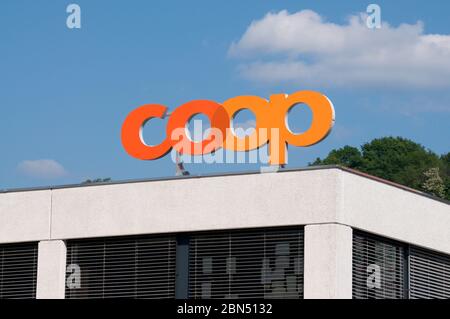 Taverne, Tessin, Schweiz - 9. Mai 2020 : Coop Supermarkt Logo Schild gegen blauen Himmel über einem Geschäft in Taverne. Die Coop Group ist eine der Schweizler Stockfoto