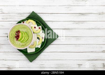 Hummus bestehend aus Avocados und grünen Erbsen, Kichererbsen in Schalen. Auf weißem Holzhintergrund, mit Brotscheiben. Kopierraum. Flacher Einlegeband Stockfoto