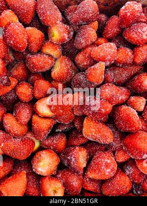 Viele gefrorene Erdbeerbeeren zum Essen im Hintergrund Stockfoto