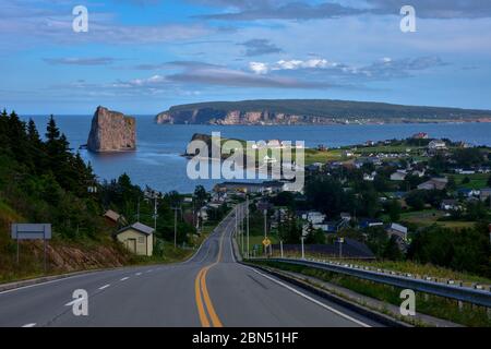 Blick auf den Hügel des Dorfes mit dem berühmten Rocher Percé in Gaspesie bei Dämmerung. Stockfoto