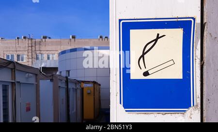 Ein blaues quadratisches Schild ist an der Wand angebracht, das den Raucherbereich auf der Straße erklärt Stockfoto