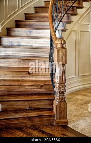 Ein schwarzer Walnuss-Newel-Pfosten am unteren Ende einer großen Treppe. Stockfoto