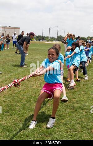 Austin Texas, USA, Mai 10 2012: Mehrere ethnische Schüler der zweiten Klasse nehmen am Tauziehen Teil, bei dem zwei Teams an einem langen Seil gegeneinander antreten. ©Marjorie Kamys Cotera/Daemmrich Photography Stockfoto