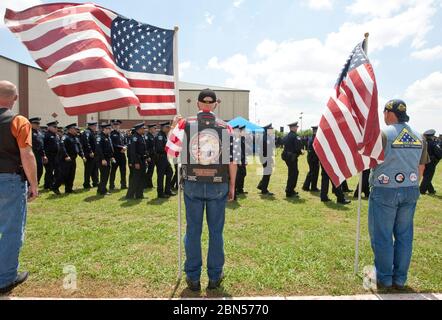 Austin, Texas, USA, April 12 2012: Militärveteranen mit amerikanischen Flaggen stehen auf der Hut, wenn sie dem Polizisten Jaime Padron, der bei seiner Beerdigung im Dienst getötet wurde, Tribun zahlen. ©Marjorie Kamys Cotera/Daemmrich Photography Stockfoto