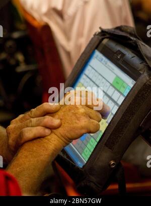 Austin Texas, USA, 10. Mai 2012: Ein körperbehinderter Mensch verwendet einen Touchscreen-Computer, der an seinem Rollstuhl befestigt ist, um zu kommunizieren. ©Marjorie Kamys Cotera/Daemmrich Photography Stockfoto