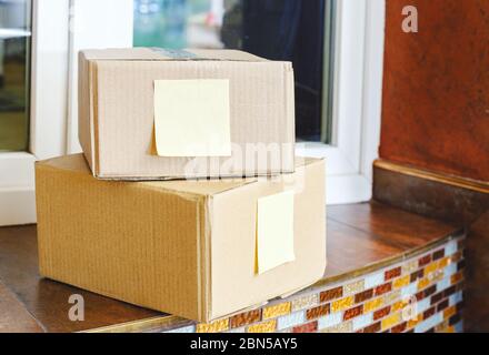 Lieferboxen vor der Haustür in der Nähe der Haustür. Kontaktlose Lebensmittelzustellung. Sicher einkaufen E-Commerce Pakete zu Hause kaufen. Die Boxen werden an die Vordertür geliefert Stockfoto