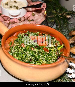 Tabbouleh ist ein levantiner vegetarischer Salat, der hauptsächlich aus fein gehackter Petersilie besteht. Frisches Essen Buffet Brunch Catering Essen Party Sharing Konzept Stockfoto