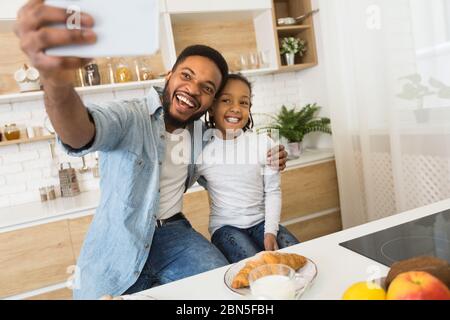 Vater und Tochter machen Selfie beim Frühstück Stockfoto