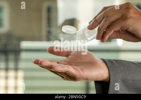 Coronavirus man Hände mit Hand Desinfektionsmittel Reinigung Hände mit einem Hand Desinfektionsmittel Gel Stockfoto