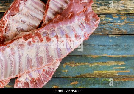 Frisches rohes Schweinefleisch mit Rippen auf altem Holzbrett Stockfoto