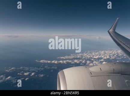 Wolken und Himmel gesehen durch Fenster eines Flugzeugs Stockfoto