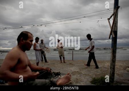 Ein Fischerdorf an der Westküste Sumatras im Dezember reparieren Fischer Angelschnur am Strand des Dorfes Malabro in Bengkulu, einer Stadt an der Westküste Sumatras mit Blick auf den Indischen Ozean. Archivbild. 1st Dezember 2012. Stockfoto