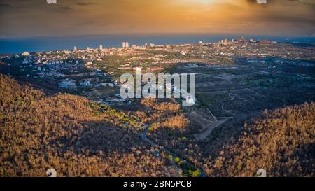 Dieses einzigartige Foto zeigt die herbstliche Hügellandschaft auf dem hin lek fai bei Sonnenuntergang! Der wunderschöne goldene Himmel über der Stadt Hua hin im Hintergrund Stockfoto