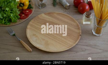 Cropped Shot von Küchentisch mit Holzteller, Gemüse auf Holzküchengeschirr und Zutaten Stockfoto