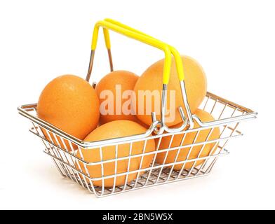 Braune Eier in einem kleinen Metallkorb auf weißem Hintergrund. Essen, Einkaufen im Laden, Supermärkte, Hühnerfarm. Stockfoto