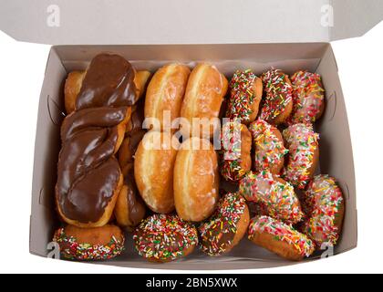 Große Box mit verschiedenen Donuts. Kuchen mit Streuseln, glasierten und schokoladenüberzogenen Wendungen und grundglasierten Donuts. Ein beliebtes amerikanisches Junk Food. Stockfoto