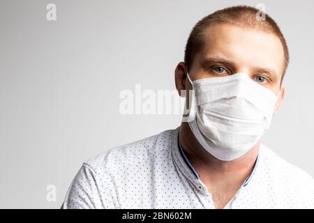 Junger Mann trägt Masken, um Luftverschmutzung, Dunst und PM 2.5 Staub- und Rauchverschmutzung auf weißem Hintergrund zu verhindern. Medizinischer Schutz vor Atemnot Stockfoto