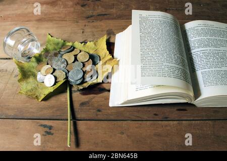 Eine alte antike indische Paise-Münzen vor dem Buch. Alte indische Vintage-Münzen auf Holzhintergrund isoliert. Gültige und ungültige indische Währung. Stockfoto