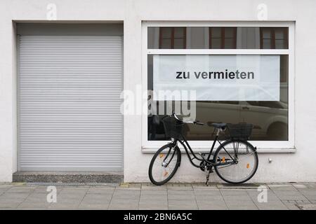 Deutsch Vakanz Zeichen im Schaufenster - zu vermieten übersetzt als zu vermieten oder zu vermieten - Fahrrad außerhalb geschlossenen Shop geparkt Stockfoto