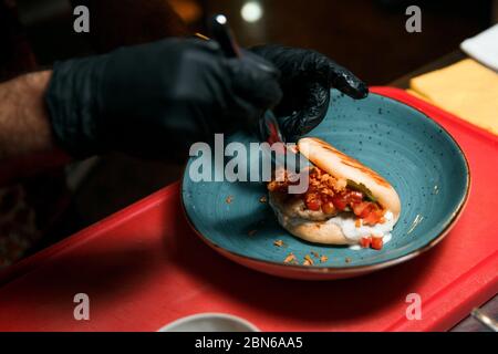 Der Koch bereitet ein Kebab-Brötchen vor. Garvorgang. Stockfoto